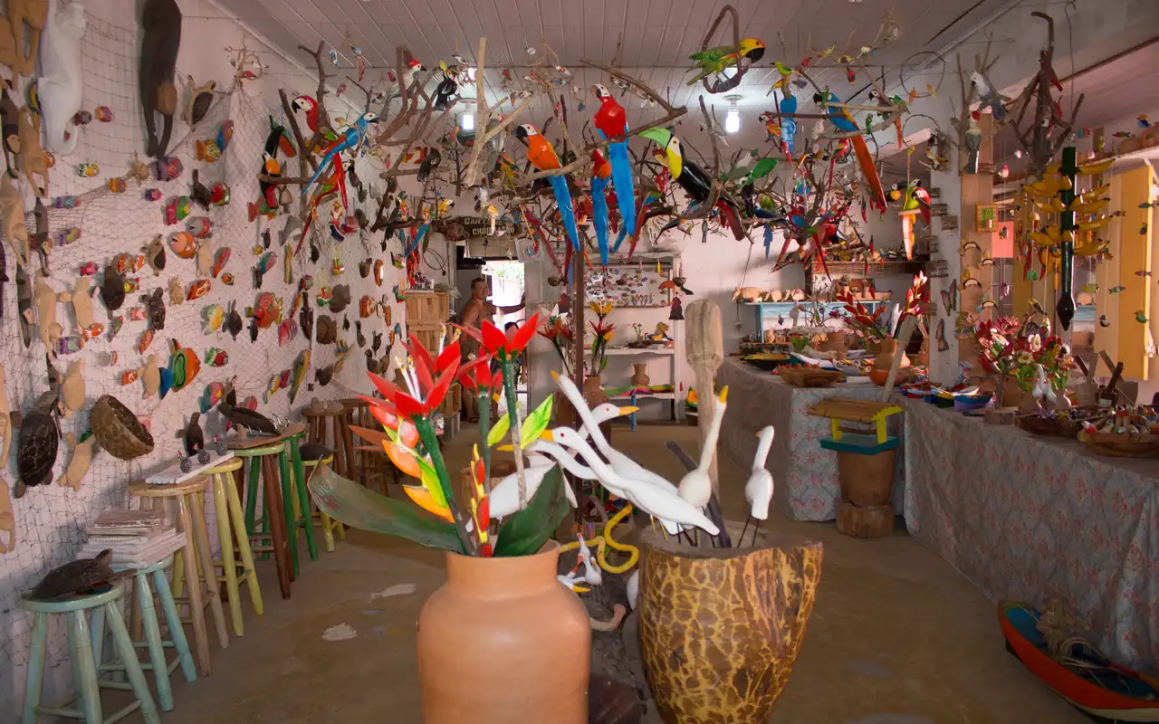 Artesanato caiçara tradicional exposto em loja local. Explorar os ateliês e a cultura do Centro Histórico é uma excelente opção de o que fazer em São Sebastião com chuva.