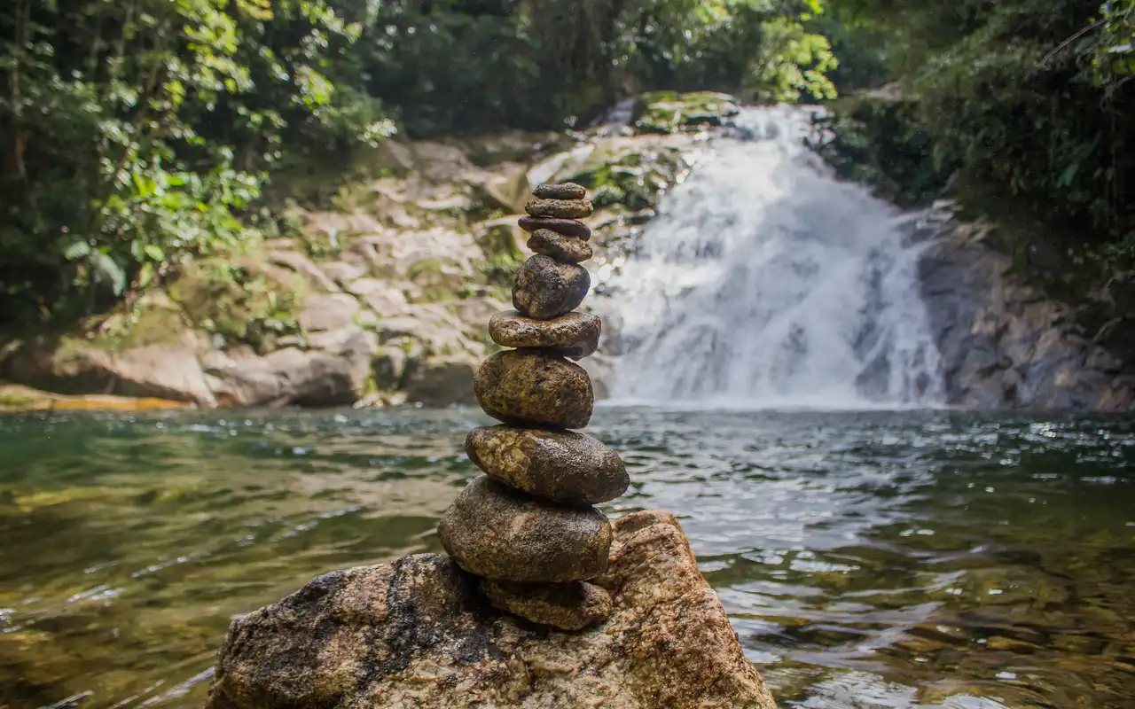 Queda d'água cercada pela Mata Atlântica. Refrescar-se nas cachoeiras da Serra do Mar é uma das melhores opções de o que fazer em São Sebastião além das praias.
