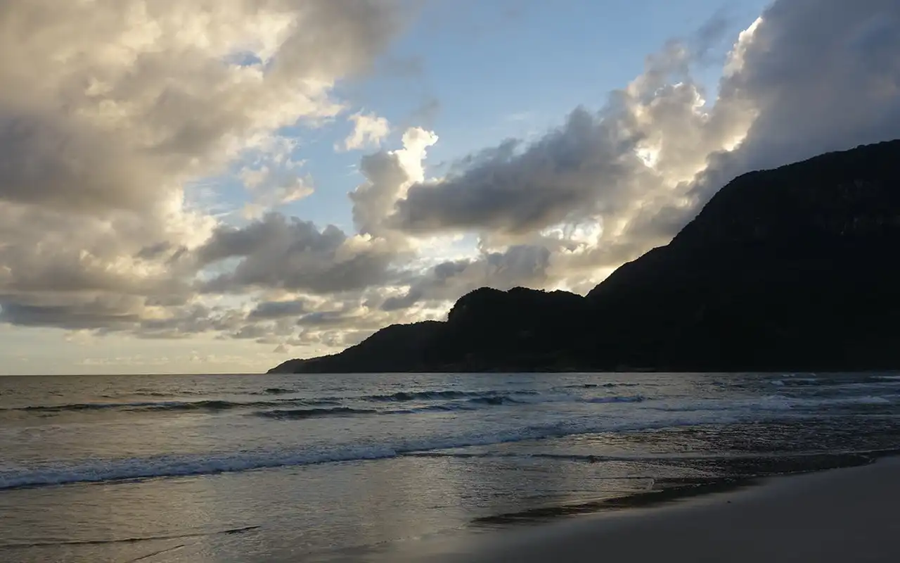 Vista direta para o mar da Praia de Guaecá em São Sebastião, SP. Águas limpas com pequenas ondas se formando e o horizonte aberto do oceano no Litoral Norte paulista.