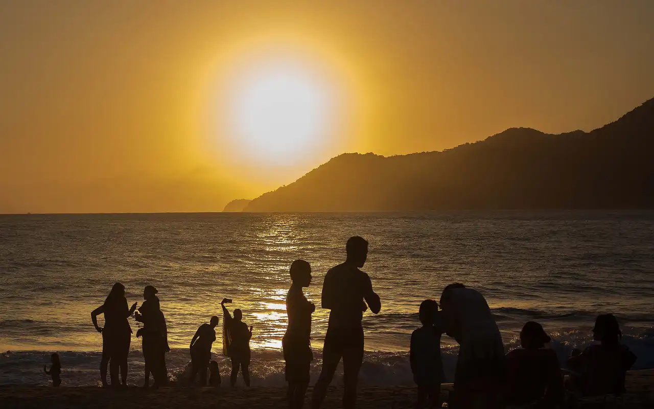 Pôr do sol na Praia de Paúba em São Sebastião, SP. Céu colorido refletindo nas águas calmas e cristalinas desta pequena enseada cercada por Mata Atlântica.